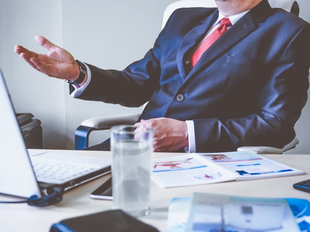 Businessman gesturing during a meeting at desk.