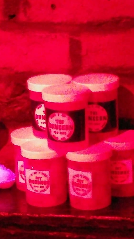 Red jars stacked against a brick wall.